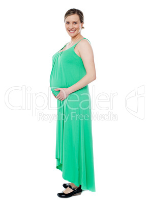 Pregnant woman posing in trendy fashion wear