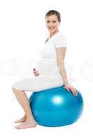 Pregnant lady sitting on exercise ball
