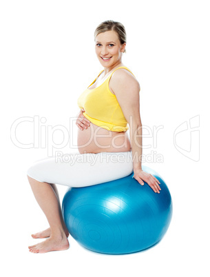 Relaxed pregnant woman sitting on pilate ball