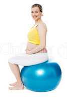 Pregnant woman sitting on gymnastic ball