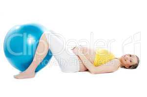 Beautiful pregnant woman lying with exercise ball