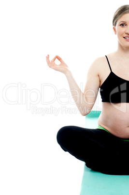 Cropped image of a pregnant lady doing yoga