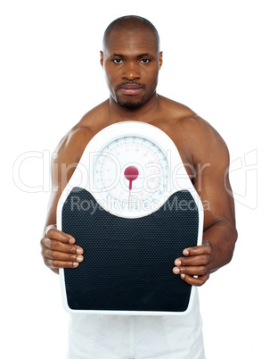 Attractive athlete showing weighing scale