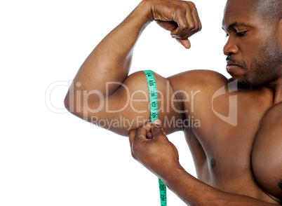 Handsome guy measuring his biceps