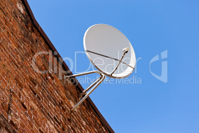 Satellite Dish mounted on old brick wall.