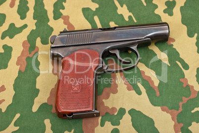 Army handgun on camouflaged background