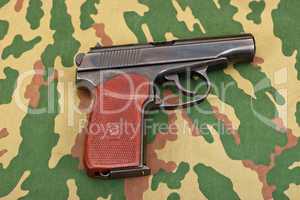 Army handgun on camouflaged background