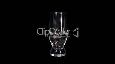 Timelapse of melting ice cubes in a glass against black background. reversing