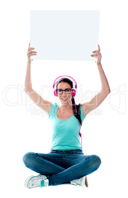 Casual musical woman holding blank billboard