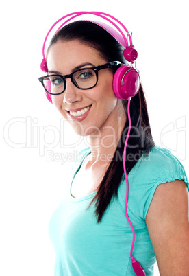 Pretty girl tuned into listening music via headphones