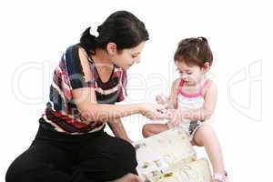 Beautiful little girl playing with her mother on the floor