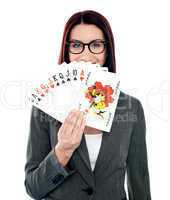 Corporate lady hiding her smile with playing cards