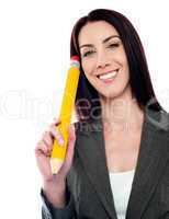 Thoughtful businesswoman holding big pencil