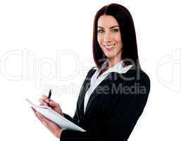 Young beautiful businesswoman writing on clipboard