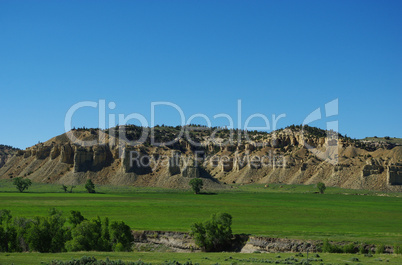 Green valley with rocky hills and blue sky, Wyoming