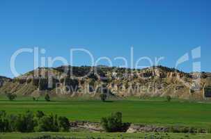 Green valley with rocky hills and blue sky, Wyoming