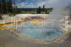 Beautiful thermal pool with view on forests and mountains, Yellowstone National Park, Wyoming