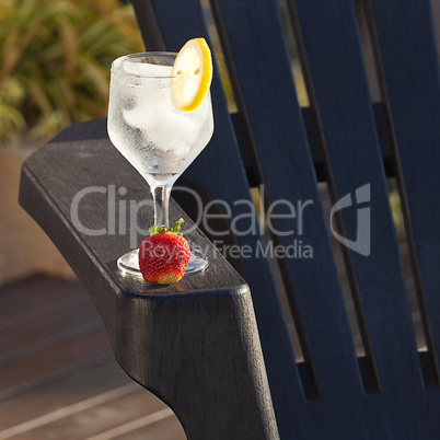 Swimming pool, lounge, a wine glass with ice, lemon and strawber