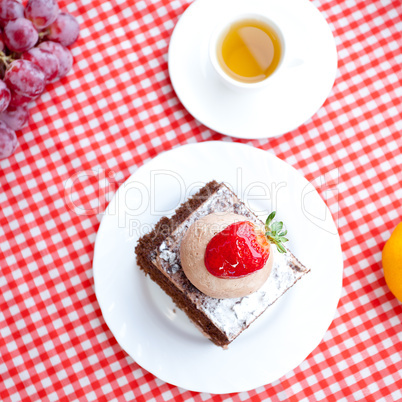 beautiful cake with strawberry,tangerine,grape and tea on plaid