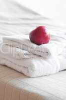 apple lying on towels on the bed
