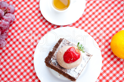 beautiful cake with strawberry,tangerine,grape and tea on plaid