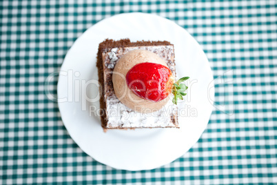 beautiful cake with strawberry on plaid fabric