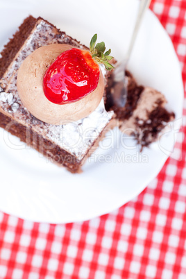 beautiful cake with strawberry on plaid fabric