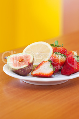 lemon, fig and strawberries on a plate