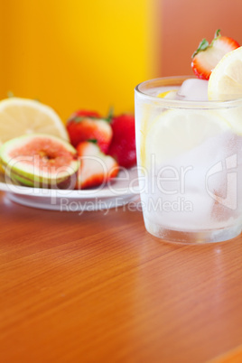 cocktail with ice,lemon, fig and strawberries on a plate