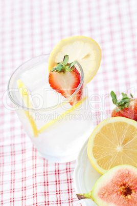 cocktail with ice,lemon, fig and strawberries on a plate