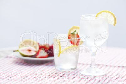 cocktail with ice,lemon, fig and strawberries on a plate