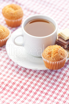 bar of chocolate,tea and muffin on plaid fabric