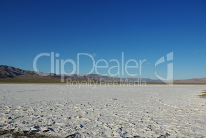 Wide salt flats and dispersed mountain chains in the desert, California