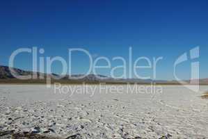 Wide salt flats and dispersed mountain chains in the desert, California