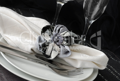 Decorative folded napkin on a plate with cutlery