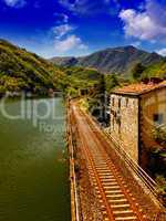 Railway with River, Sky and Vegetation in Tuscany