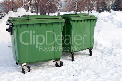 Two green recycling containers in winter park