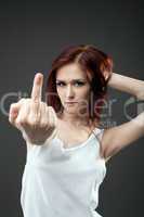 Anger young woman in tank top with fuck sign