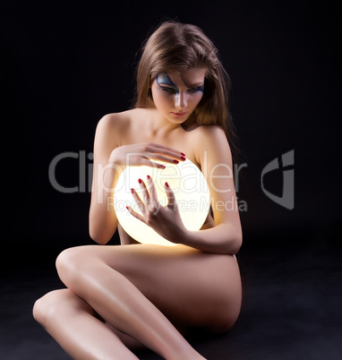 Nude young woman with lamp like pearl