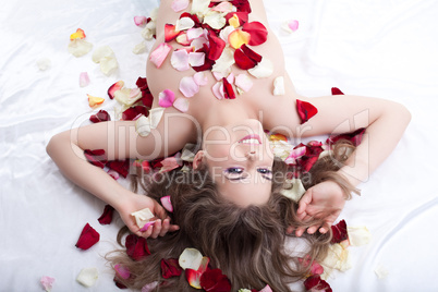 Young woman in rose petals