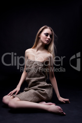 Beautiful young woman sitting on floor