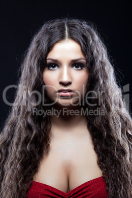 Young beautiful serious girl with curly hair