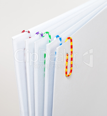 White sheets of paper with colorful paper clips