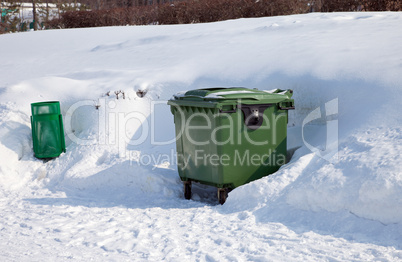 Green dumpster in the winter park