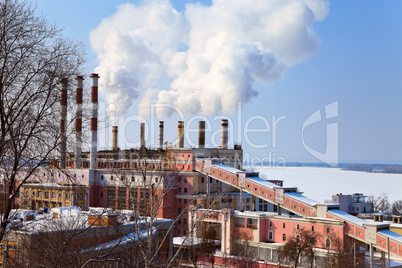 Large factory with smoking chimneys against the blue sky