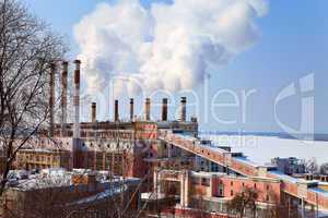 Large factory with smoking chimneys against the blue sky