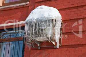 Air conditioning heat pump mounted on brick wall.