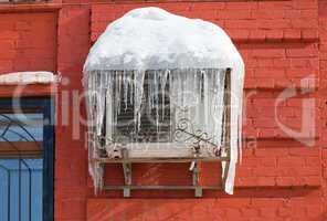 Air conditioning heat pump mounted on brick wall.