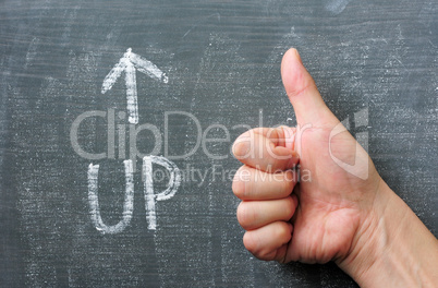 Up - word written on a blackboard with an arrow and thumb up gesture