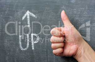 Up - word written on a blackboard with an arrow and thumb up gesture